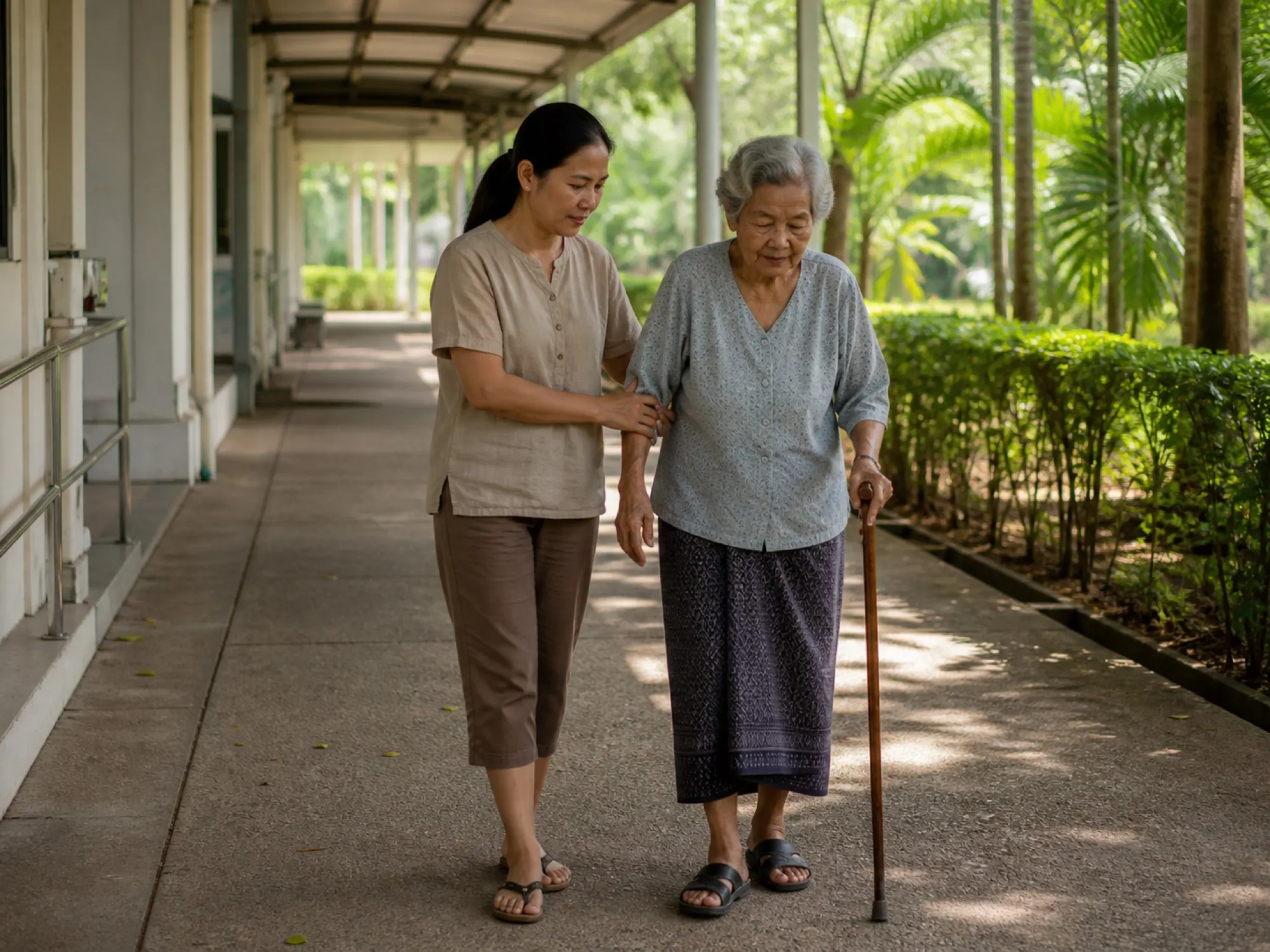 ผู้ดูแลร่วมทางเดินประคองผู้สูงอายุไปโรงพยาบาล